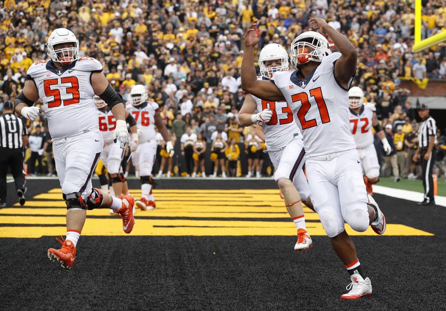FILE - In this Oct. 7, 2017, file photo, Illinois running back Ra'Von Bonner (21) celebrates after scoring on a two-yard touchdown run during the first half of an NCAA college football game against Iowa in Iowa City, Iowa. Illinois piled up 200 rushing yards in a loss at Iowa last weekend, using primarily three running backs to do it. The Illini are hoping to ride the run to a win at home against Rutgers this Saturday. (AP Photo/Charlie Neibergall, File)