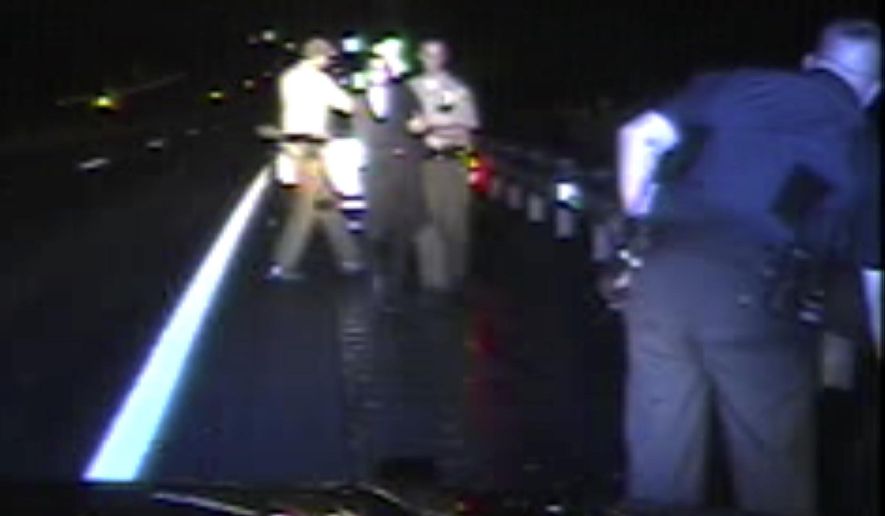 File - In this Aug. 8, 2017, file from dashboard video released by the Vermont State Police, troopers detain passenger Rabbi Eli Fink, rear, and driver Rabbi Berl Fink, off camera at right, during a traffic stop in Thetford, Vt. The attorney for the rabbi who drove for 4.5 miles after a Vermont state trooper tried to pull him over for speeding on a remote interstate highway says he's hopeful the case can be resolved without Fink having to appear in court. (Vermont State Police via AP, File)