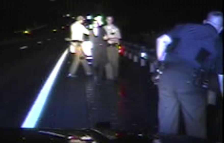 File - In this Aug. 8, 2017, file from dashboard video released by the Vermont State Police, troopers detain passenger Rabbi Eli Fink, rear, and driver Rabbi Berl Fink, off camera at right, during a traffic stop in Thetford, Vt. The attorney for the rabbi who drove for 4.5 miles after a Vermont state trooper tried to pull him over for speeding on a remote interstate highway says he's hopeful the case can be resolved without Fink having to appear in court. (Vermont State Police via AP, File)