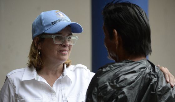 In this Sept. 30, 2017, file photo San Juan, Puerto Rico, Mayor Carmen Yulin Cruz speaks with a man as she arrives at San Francisco hospital in the Rio Piedras area of the city as about 35 patients are evacuated after the failure of an electrical plant. The AP reported on Oct. 13, 2017, that a story claiming San Juan&#39;s city council has moved to impeach Cruz was false. (AP Photo/Carlos Giusti, File)