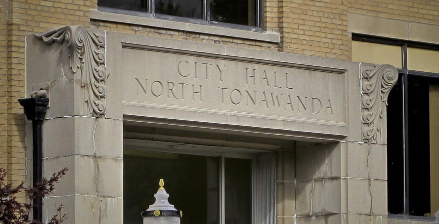 This photo shows signage above the entrance to North Tonawanda's City Hall where its city council resides, Thursday, Oct. 12, 2017, in New York. The council voted unanimously Oct. 3 to amend an existing law to add bullying, harassment and underage drinking to existing curfew violations parents already could be held accountable for. (AP Photo/Carolyn Thompson)