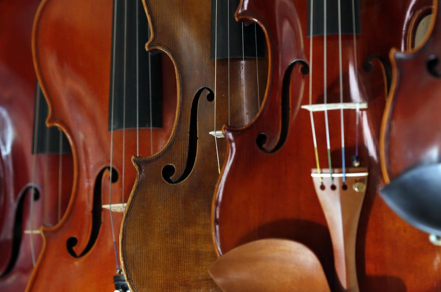 Different violins hanging on the wall in violin maker Jan Nemcek's work shop, in the northern Serbian village of Kovacica, Wednesday, Oct. 4, 2017. Nemcek picks up his own wood from the forest, cuts and dries it himself and then slowly and patiently moulds it into a musical instrument. Nemcek is a violin maker a rare one that makes violins the old way _ using no machines, but only his hands and tools. (AP Photo/Darko Vojinovic)