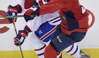 Montreal Canadiens left wing Charles Hudon (54) and Washington Capitals defenseman Matt Niskanen (2) battle for the puck during the third period of a NHL hockey game, Saturday, Oct. 7, 2017, in Washington. The Capitals won 6-1. (AP Photo/Nick Wass)