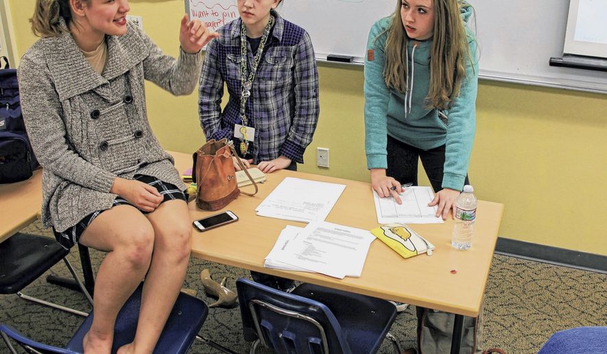In this Monday, Oct. 2, 2017, photo, Eagle River High School students, from left, Jenni Hunting, Sara George and Alina Cook discuss story ideas during a meeting of the ERHS newspaper club in Eagle River, Alaska. The new school newspaper plans on publishing its first print edition this fall. (Kirsten Swann/Alaska Journal of Commerce via AP)
