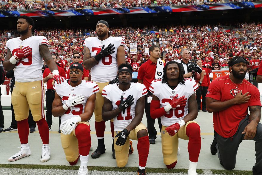 Member of the San Francisco 49ers kneel and stand during the playing of the National Anthem before an NFL football game against the Washington Redskins in Landover, Md., Sunday, Oct. 15, 2017. Kneeling are (L-R) strong safety Eric Reid (35), wide receiver Marquise Goodwin (11) and defensive back Adrian Colbert (38). (AP Photo/Alex Brandon)