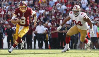 Washington Redskins quarterback Kirk Cousins (8) carries the ball toward the end zone a touchdown as San Francisco 49ers defensive end Solomon Thomas (94) looks on during the second half of an NFL football game in Landover, Md., Sunday, Oct. 15, 2017. (AP Photo/Alex Brandon)