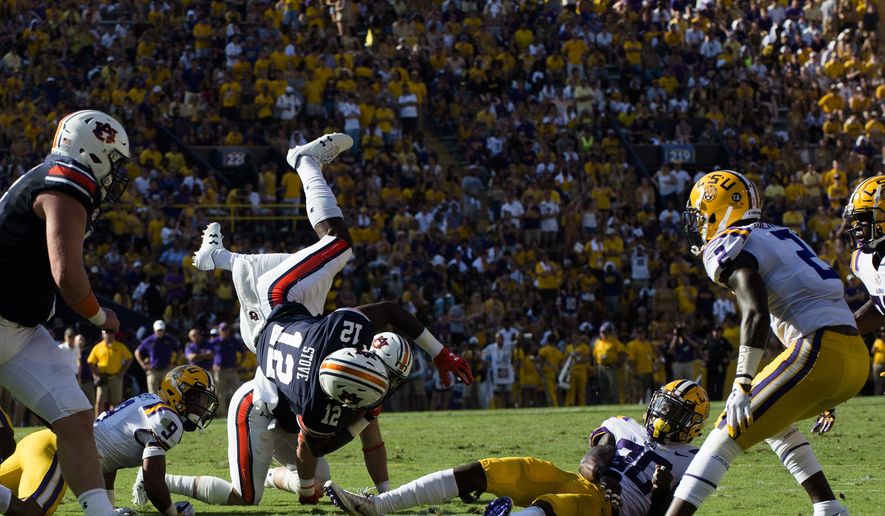 Auburn wide receiver Eli Stove (12) is tackled by LSU defensive back Eric Monroe (30) during an NCAA college football game in Baton Rouge, La., Saturday, Oct. 14, 2017. (Albert Cesare/The Montgomery Advertiser via AP)