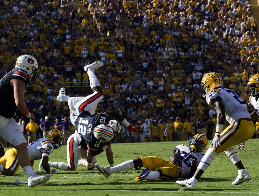 Auburn wide receiver Eli Stove (12) is tackled by LSU defensive back Eric Monroe (30) during an NCAA college football game in Baton Rouge, La., Saturday, Oct. 14, 2017. (Albert Cesare/The Montgomery Advertiser via AP)