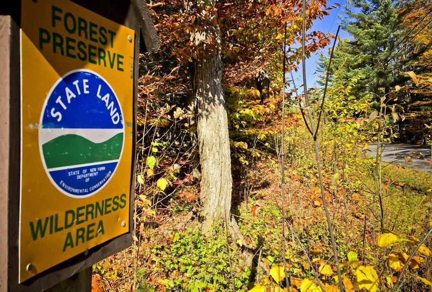 This Oct. 12, 2017 photo shows a sign marking state Forest Preserve land near a road where local officials want to put a bike lane, in Piseco Lake, N.Y. The project, which stalled because of a state constitution violation of Adirondack Forest Preserve land, could get the green light when it goes before New York voters in November. (AP Photo/Mary Esch)