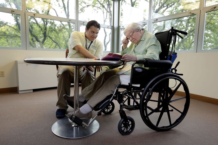 William Bazan, 20, in the HOPE program at the Hebrew Home at Riverdale, in New York, works on his reading skills with resident Selma Bachner, 90, in an atrium of the facility Thursday, May 25, 2017. The nursing home on a picturesque stretch of the Hudson River in the Bronx, has gone beyond its calling as a house for the old, playing host to the young with an innovative public high school right within its walls. She works with William on reading, helping when he stumbles on a word and cajoling him as he answers a workbook’s comprehension questions. “It makes me feel darn good to help a young person,” Bachner says. (AP Photo/Richard Drew)