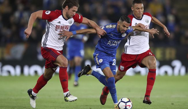 Leicester City&#x27;s Riyad Mahrez, center, breaks through West Bromwich Albion&#x27;s Grzegorz Krychowiak and Kieran Gibbs, right, during the English Premier League soccer match at the King Power Stadium, Leicester, England, Monday, Oct. 16, 2017. (Nick Potts/PA via AP)