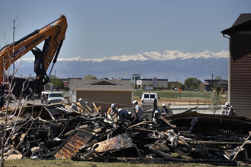 FILE - In this May 4, 2017, file photo, workers dismantle the charred remains of a house where an explosion killed two people in Firestone, Colo. Investigators blamed the explosion on gas leaking from a flow line that was believed to be out of service but was still connected to a well. Colorado is proposing tighter rules for taking oil and gas pipelines out of service after the incident. (AP Photo/Brennan Linsley, File)