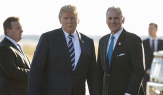 President Donald Trump stands on the tarmac with South Carolina Gov. Henry McMaster as he arrives on Air Force One at Greenville Spartanburg International Airport, in Greer, S.C., Monday, Oct. 16, 2017, en route Greenville, S.C., for a fundraiser for McMaster. (AP Photo/Carolyn Kaster)
