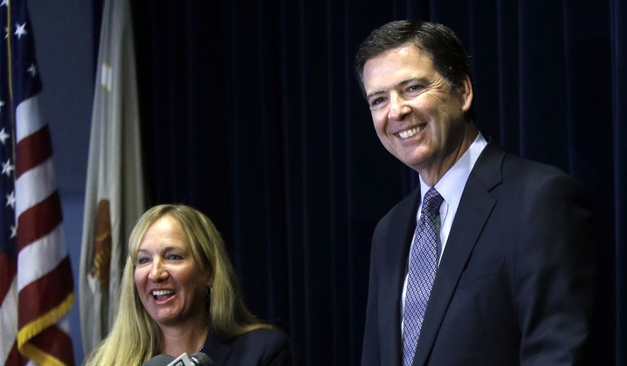 In this Oct. 1, 2014, file photo, then-FBI Director James B. Comey, right, is joined by U.S. Attorney Amanda Marshall during a news conference in Portland, Ore. (AP Photo/Don Ryan, File)