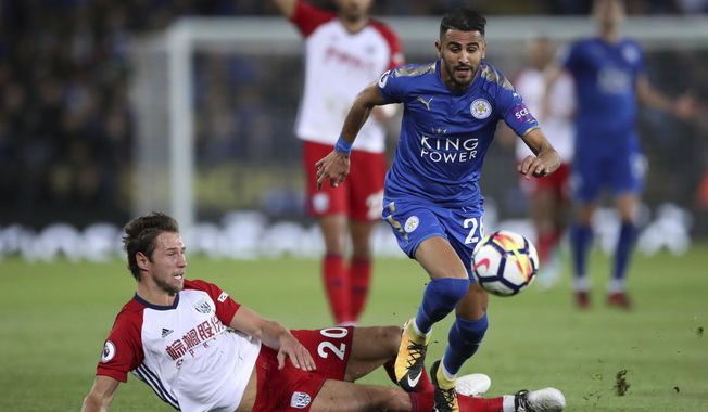 Leicester City&#x27;s Riyad Mahrez is challenged by West Bromwich Albion&#x27;s Grzegorz Krychowiak, left, during the English Premier League soccer match at the King Power Stadium, Leicester, England, Monday, Oct. 16, 2017. (Nick Potts/PA via AP)