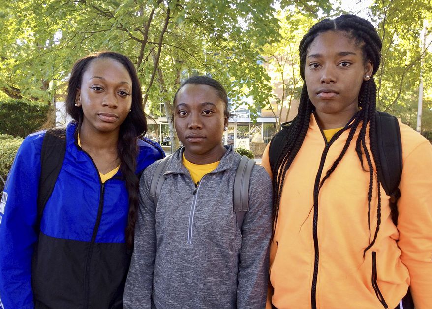 Kennesaw State University cheerleaders, from left to right, Shlondra Young, Tommia Dean and Kennedy Town stand outside the student center on the school's campus in Kennesaw, Ga., Monday, Oct. 16, 2017. The three are part of a group of cheerleaders from the Georgia college that say they'll take a knee in the stadium tunnel when the national anthem is played at Saturday's homecoming game since their university moved them off the field after an earlier demonstration. (AP Photo/Jeff Martin)