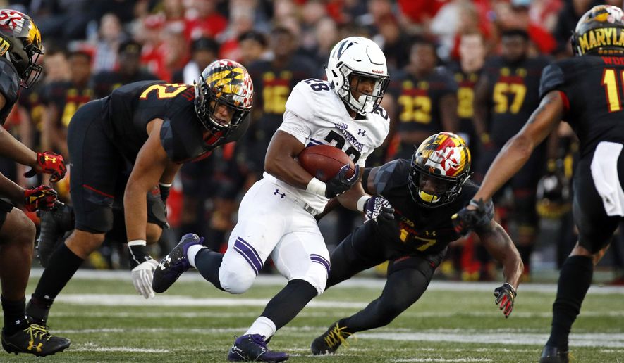 FILE - In this Saturday, Oct. 14, 2017, file photo, Northwestern running back Jeremy Larkin, center, rushes past Maryland defenders in the second half of an NCAA college football game in College Park, Md. After giving up 37 points and 531 yards to Northwestern last week, Maryland needs to improve its defense in a hurry before facing No. 5 Wisconsin on Saturday. (AP Photo/Patrick Semansky, File)