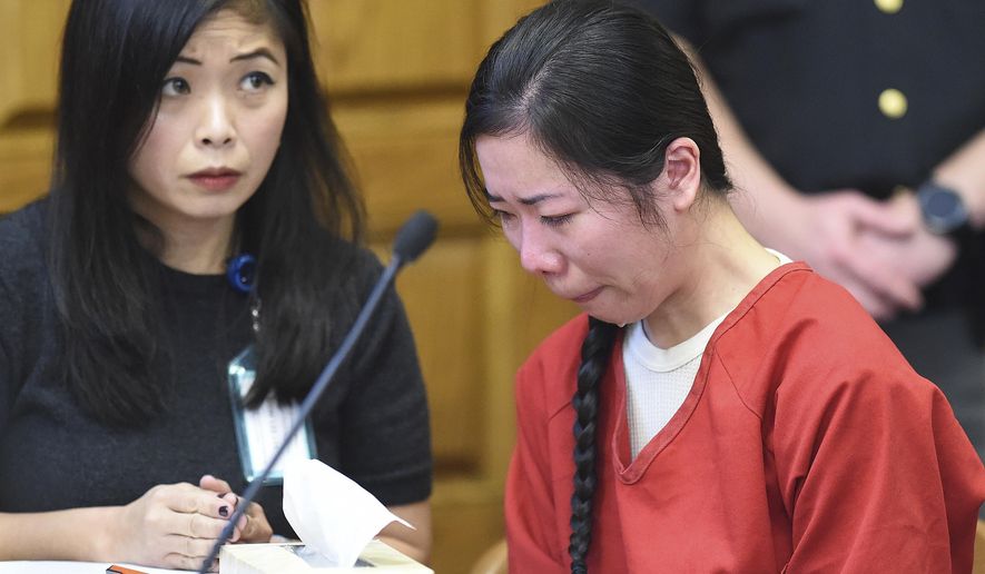 Mingming Chen, right, attends a hearing where her defense attorney argued that a police interview in which Chen acknowledged killing her 5-year-old daughter should be excluded from the Chinese woman's murder trial because a translator wasn't present, on Monday, Oct. 16, 2017, in Stark County Common Pleas Court in Canton, Ohio. Chen, of Jackson Township, Ohio, pleaded not guilty by reason of insanity Thursday, Oct. 12, 2017, in the death of Ashley Zhao, whose body was found hidden in the family's North Canton, Ohio, restaurant on Jan. 10, 2017, a day after she was reported missing. Chen cried as portions of a police interview were played Monday, Oct. 16, 2017, on a projection screen in the courtroom. (Michael Balash/The Canton Repository via AP)