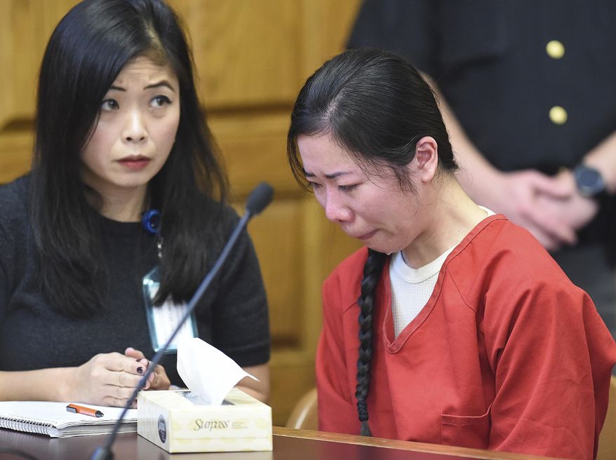 Mingming Chen, right, attends a hearing where her defense attorney argued that a police interview in which Chen acknowledged killing her 5-year-old daughter should be excluded from the Chinese woman's murder trial because a translator wasn't present, on Monday, Oct. 16, 2017, in Stark County Common Pleas Court in Canton, Ohio. Chen, of Jackson Township, Ohio, pleaded not guilty by reason of insanity Thursday, Oct. 12, 2017, in the death of Ashley Zhao, whose body was found hidden in the family's North Canton, Ohio, restaurant on Jan. 10, 2017, a day after she was reported missing. Chen cried as portions of a police interview were played Monday, Oct. 16, 2017, on a projection screen in the courtroom. (Michael Balash/The Canton Repository via AP)