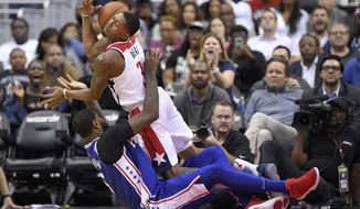 Washington Wizards guard Bradley Beal (3) is fouled by Philadelphia 76ers forward Amir Johnson, bottom, during the second half of an NBA basketball game, Wednesday, Oct. 18, 2017, in Washington. The Wizards won 120-115. (AP Photo/Nick Wass)