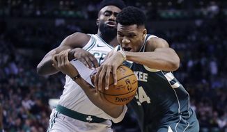 Milwaukee Bucks forward Giannis Antetokounmpo, right, tries to drive past Boston Celtics forward Jaylen Brown, left, during the first quarter of an NBA basketball game, Wednesday, Oct. 18, 2017, in Boston. (AP Photo/Charles Krupa)