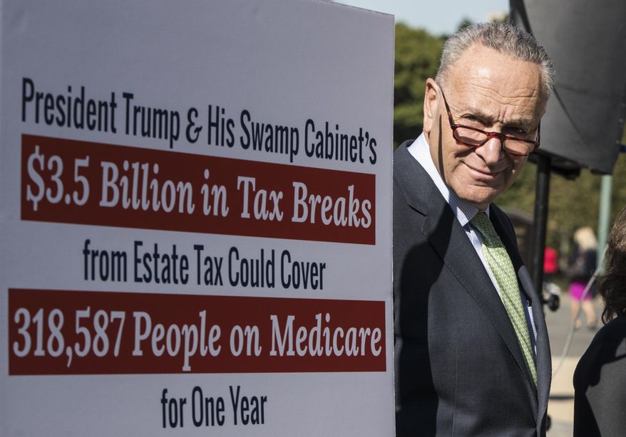 Senate Minority Leader Chuck Schumer, D-N.Y., stands beside a poster critical of the Republican tax and budget proposals during a news conference, at the Capitol in Washington, Wednesday, Oct. 18, 2017. (AP Photo/J. Scott Applewhite)