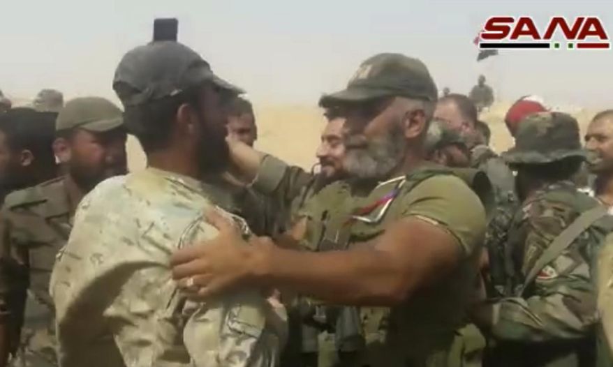 This frame grab from a video released on September 5, 2017 by the Syrian official news agency SANA, shows Syrian army senior commander Brig. Gen. Issam Zahreddine, right, who led the fight against Islamic Sate militants in the eastern city of Deir el-Zour congratulates a Syrian army soldier, at a front line, in Deir el-Zour, Syria. The Central Military Media said on Wednesday, Oct. 18, 2017, that Zahreddine was killed in Hawija Saqr, east of Deir el-Zour, in operations against IS militants. (SANA via AP)