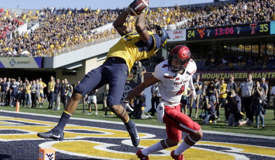 FILE - In this Oct. 14, 2017, file photo, West Virginia wide receiver Ka&#x27;Raun White (2) catches a touchdown pass in front of Texas Tech defensive back Desmon Smith (4) during the second half of an NCAA college football game in Morgantown, W.Va. Ka&#x27;Raun White caught two fourth-quarter touchdown passes in West Virginia’s 46-35 win over Texas Tech on Saturday. (AP Photo/Raymond Thompson, File)