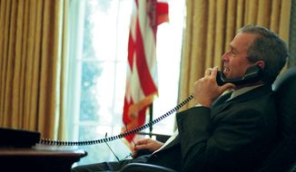 President George W. Bush has a telephone conversation in the Oval Office after finishing his first 100 days in office on April 30, 2001. (The Washington Times)