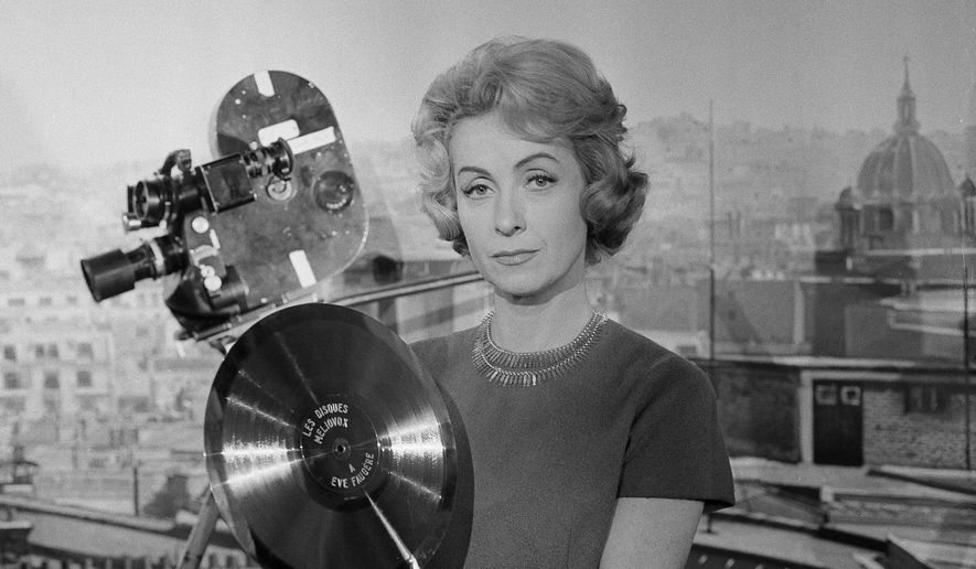In this Dec. 27, 1959, file photo, French actress and singer Danielle Darrieux holds up a prop gold record at the Paris Saint-Maurice studios. Darrieux, a prolific French actress whose movie and theater career spanned eight decades, has died. She was 100. (AP Photo, File)
