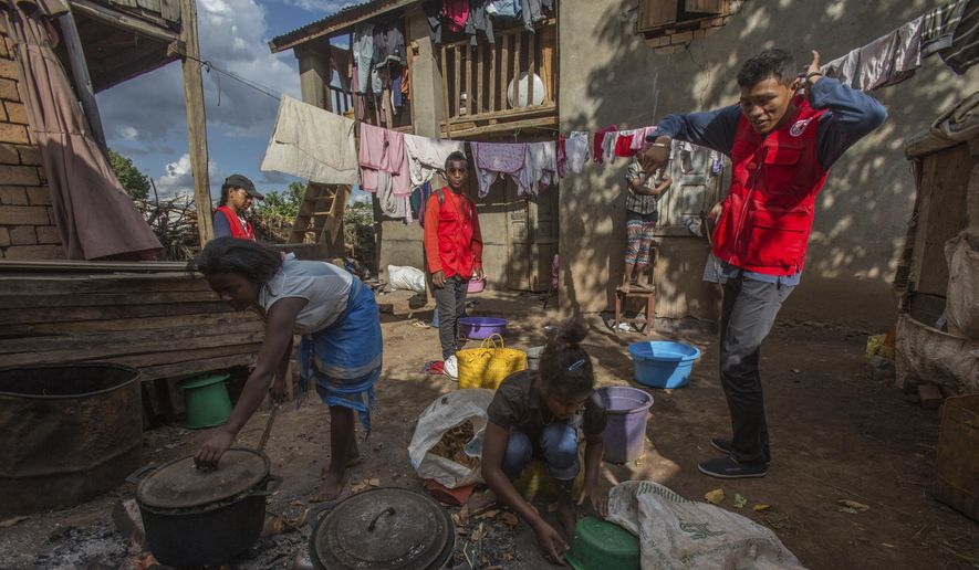 Red Cross volunteers speak to women as they are busy cooking, whilst educating villagers about the plague outbreak, 30 miles west of Antananarivo, Madagascar, Monday, Oct. 16, 2017. As plague cases rose last week in Madagascar&#39;s capital, many city dwellers panicked. They waited in long lines for antibiotics at pharmacies and reached through bus windows to buy masks from street vendors. Schools have been canceled, and public gatherings are banned. (AP Photo/Alexander Joe)