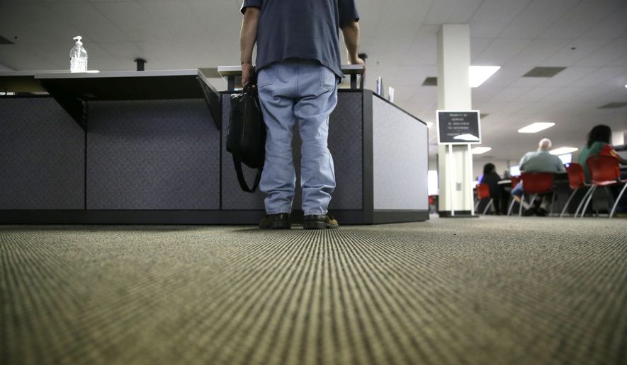 In this Friday, March 10, 2017, file photo, a lone job seeker checks in at the front desk of the Texas Workforce Solutions office in Dallas. (AP Photo/LM Otero, File)