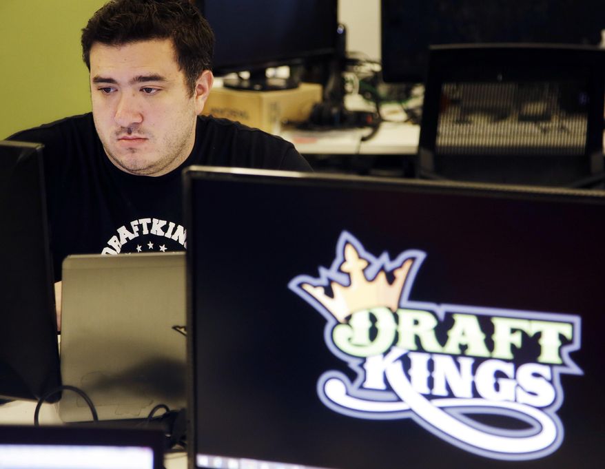 FILE - In this Sept. 9, 2015, file photo, Len Don Diego, marketing manager for content at the DraftKings daily fantasy sports company, works at his station at the company's offices in Boston. Michigan state Sen. Curtis Hertel Jr., D-East Lansing, is sponsoring legislation to regulate and make legal daily fantasy sports games popularized by sites such as FanDuel and DraftKings. (AP Photo/Stephan Savoia, File)