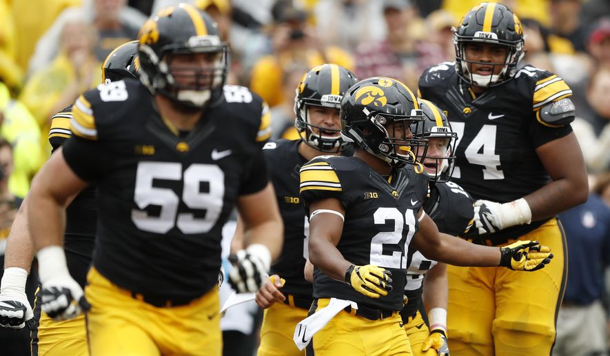 Iowa running back Ivory Kelly-Martin (21) celebrates with teammates after catching a 3-yard touchdown pass during the second half of an NCAA college football game against Illinois, Saturday, Oct. 7, 2017, in Iowa City, Iowa. Iowa won 45-16. (AP Photo/Charlie Neibergall)
