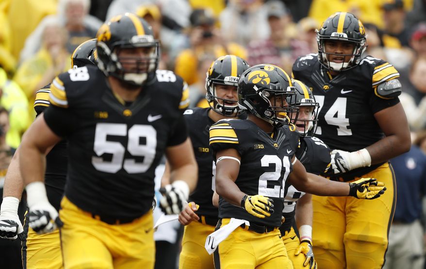 Iowa running back Ivory Kelly-Martin (21) celebrates with teammates after catching a 3-yard touchdown pass during the second half of an NCAA college football game against Illinois, Saturday, Oct. 7, 2017, in Iowa City, Iowa. Iowa won 45-16. (AP Photo/Charlie Neibergall)