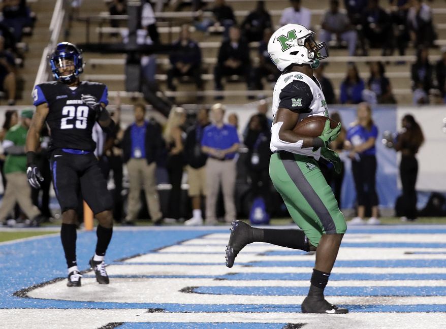 Marshall running back Keion Davis (24) scores a touchdown ahead of Middle Tennessee cornerback Darryl Randolph (29) in the first half of an NCAA college football game Friday, Oct. 20, 2017, in Murfreesboro, Tenn. (AP Photo/Mark Humphrey)