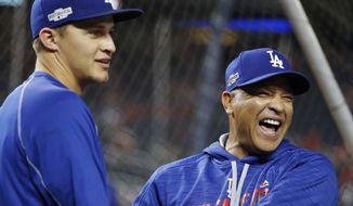 FILE - In this Oct. 13, 2016, file photo, Los Angeles Dodgers manager Dave Roberts, right, jokes with shortstop Corey Seager during batting practice before Game 5 of baseball&#39;s National League Division Series against the Washington Nationals at Nationals Park in Washington. The Dodgers earned a four-day break before the World Series with their quick resolution of the NLCS. (AP Photo/Pablo Martinez Monsivais, File)