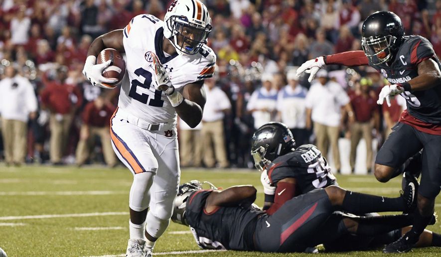 Auburn running back Kerryon Johnson, left, runs around the Arkansas defense to score a touchdown in the first half of an NCAA college football game in Fayetteville, Ark., Saturday, Oct. 21, 2017. (AP Photo/Michael Woods)