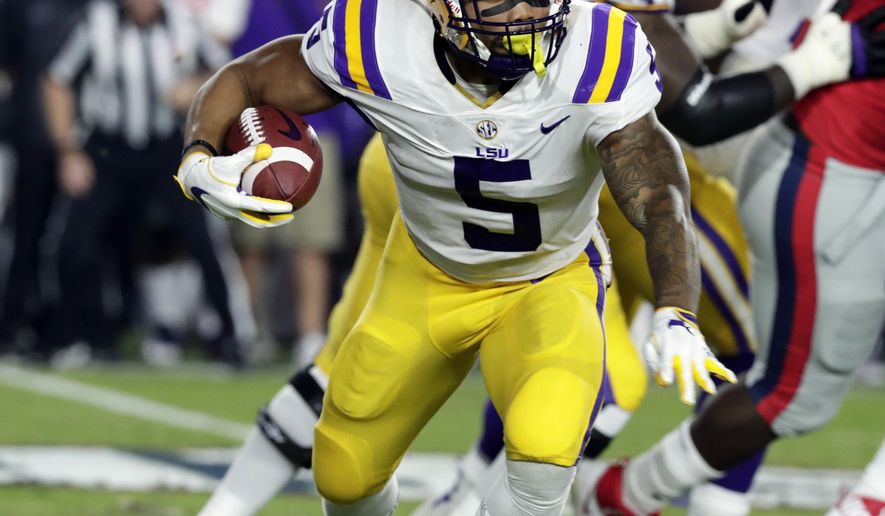 LSU running back Derrius Guice (5) runs for a first down past Mississippi defenders in the first half of an NCAA college football game in Oxford, Miss., Saturday, Oct. 21, 2017. (AP Photo/Rogelio V. Solis)