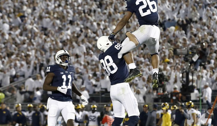 Penn State's Saquon Barkley (26) celebrates with Mike Gesicki (88) after scoring a touchdown against Michigan during the second half of an NCAA college football game in State College, Pa., Saturday, Oct. 21, 2017. Penn State won 42-13. (AP Photo/Chris Knight)