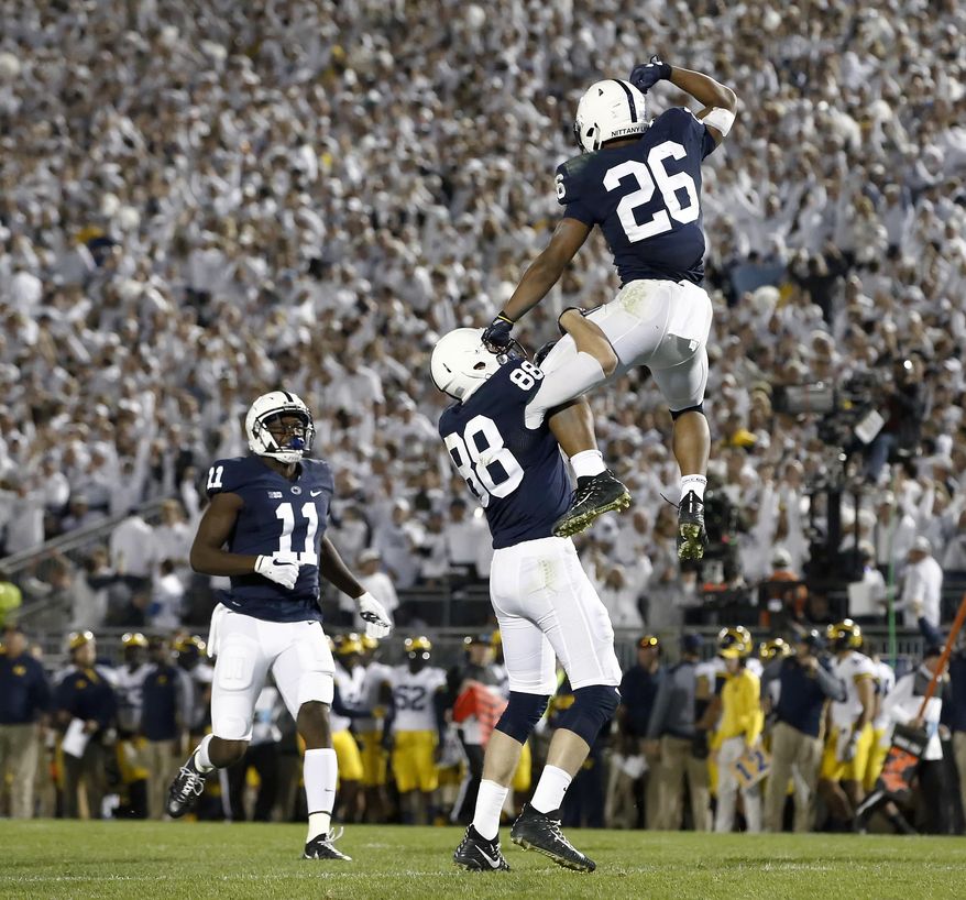 Penn State's Saquon Barkley (26) celebrates with Mike Gesicki (88) after scoring a touchdown against Michigan during the second half of an NCAA college football game in State College, Pa., Saturday, Oct. 21, 2017. Penn State won 42-13. (AP Photo/Chris Knight)