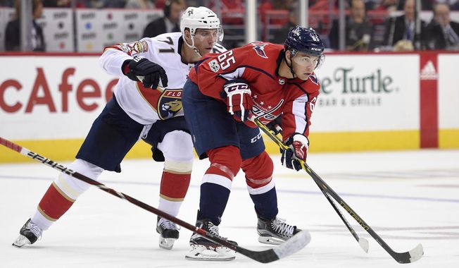 Washington Capitals left wing Andre Burakovsky (65), of Austria, skates with the puck in front of Florida Panthers right wing Radim Vrbata, back, of the Czech Republic, during the second period of an NHL hockey game, Saturday, Oct. 21, 2017, in Washington. (AP Photo/Nick Wass)