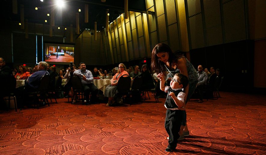 In a Tuesday, Sept. 12, 2017 photo, Joey Shewey walks with the help of caregiver Victoria Gidenko at the SKEF luncheon at the Salem Convention Center. Shewey, who uses a walker for assistance, walked in the Awesome 3000 with the encouragement of SKEF employee Hilary Brik-Morris, who was honored at the luncheon.  (Molly J. Smith/Statesman-Journal via AP)