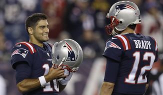 New England Patriots quarterbacks Jimmy Garoppolo, left, and Tom Brady speak while warming up before an NFL football game against the Atlanta Falcons, Sunday, Oct. 22, 2017, in Foxborough, Mass. (AP Photo/Charles Krupa) **FILE**