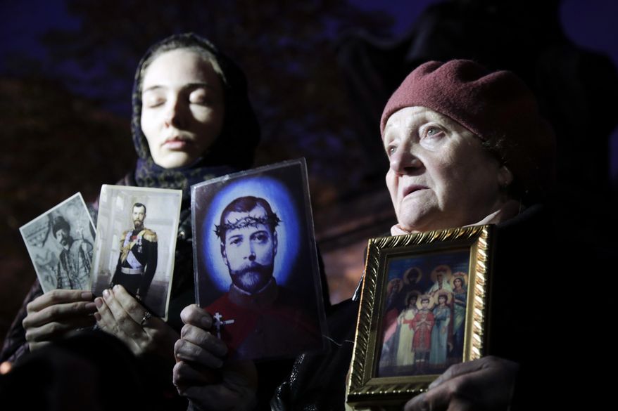 Orthodox protesters hold portraits and icons of of Russia's last czar, Nicholas II, as they protest the release of the movie "Matilda," outside the Mariinsky Theatre in Moscow, Russia, Monday, Oct. 23, 2017. About 20 Orthodox believers have sung prayers to protest the release of a movie about the last Russian czar’s affair with a ballerina. They gathered outside the Mariinsky Theater where “Matilda” was shown Monday to a selected audience ahead of its release this week. (AP Photo/Dmitri Lovetsky)