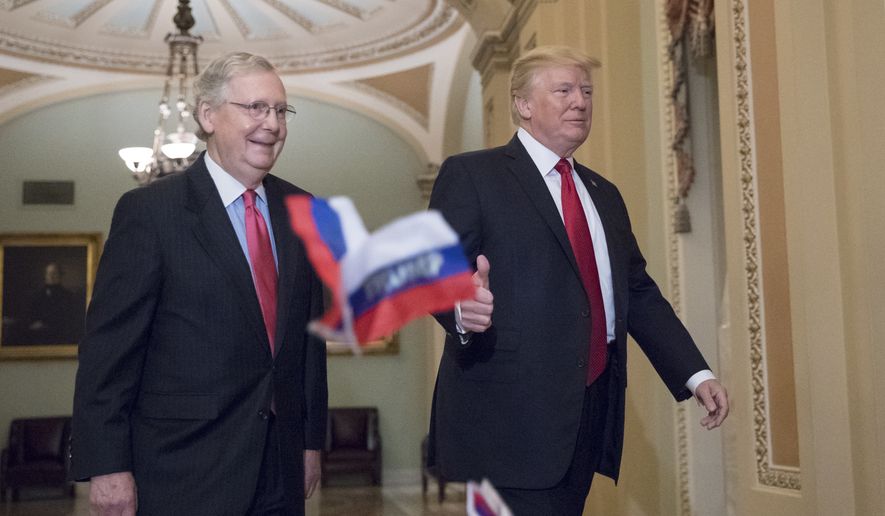 Small Russian flags with the word &quot;Trump&quot; written on them are thrown by a protester as President Donald Trump, escorted by Senate Majority Leader Mitch McConnell, R-Ky., arrives on Capitol Hill to have lunch with Senate Republicans and push for his tax reform agenda, in Washington, Tuesday, Oct. 24, 2017. (AP Photo/J. Scott Applewhite)