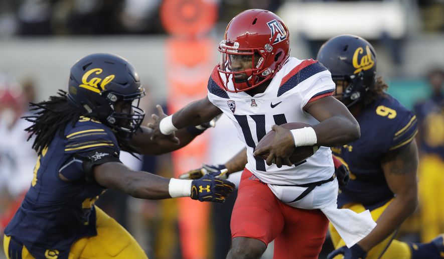 FILE - In this Saturday, Oct. 21, 2017, file photo, Arizona quarterback Khalil Tate, center, runs for a touchdown past California linebacker Alex Funches, left, during the first half of an NCAA college football game in Berkeley, Calif. Arizona's quarterback situation was resolved three games ago when Tate took over as starter. Other Pac-12 teams haven't had the same success in navigating mid-season QB quandaries. Injuries have impacted Oregon and Oregon State at the position. (AP Photo/Marcio Jose Sanchez, File)