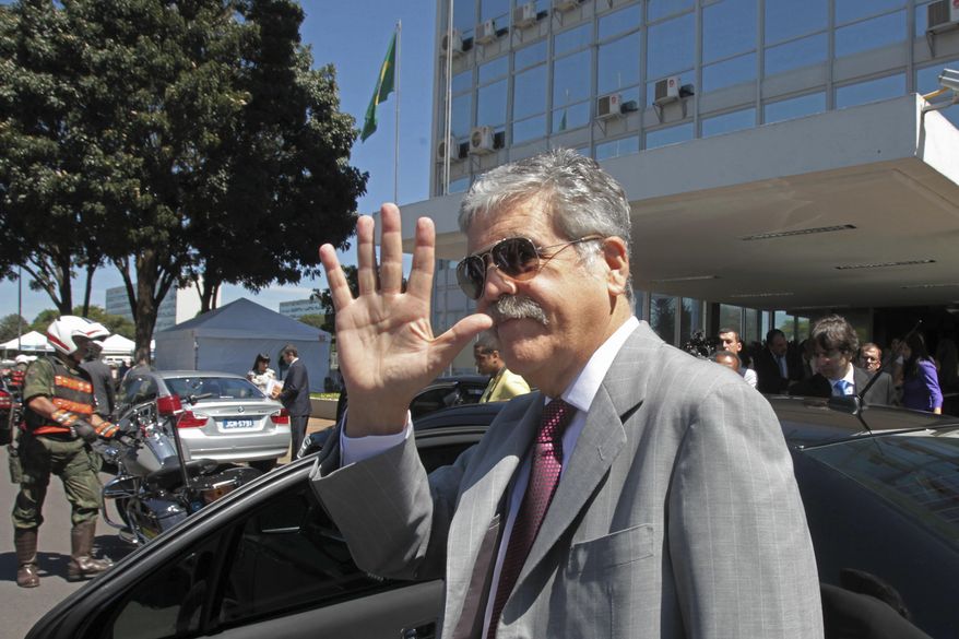 FILE- In this April 20, 2012 file photo, Argentina's then Planning Minister Julio de Vido waves to media as he leaves the Ministry of Mines and Energy in Brasilia, Brazil. Argentina's Congress is considering stripping De Vido of his immunity as current legislator, since he is being accused of corruption. (AP Photo/Eraldo Peres)