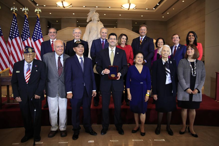 Speaker of the House Paul Ryan of Wis., presents the Congressional Gold Medal to Filipino veterans of World War II and their next of kin, from left, Celestino Almeda, Frank Francone, Aquilino Delen, Ryan, Alicia Benitez, Margrit Baltazar and Caroline Burkhart, during a ceremony at the Emancipation Hall on Capitol Hill in Washington, Wednesday, Oct. 25, 2017. Standing with the recipients are, from left back row, Veterans Affairs Secretary David Shulkin, Senate Majority Leader Mitch McConnell of Ky., Senate Minority Leader Chuck Schumer of New York, House Minority Leader Nancy Pelosi of Calif., Sen. Dean Heller, R-Nev., Sen. Mazie Hirono, D-Hi., Rep. Ed Royce, R-Calif., and Rep. Tulsi Gabbard, D-Hi. (AP Photo/Manuel Balce Ceneta)
