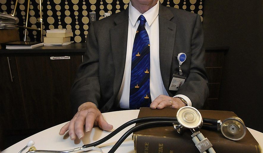 Dr. Gerald Tracy, a clinical professor at the Geisinger Commonwealth School of Medicine in Scranton, with an 1892 first edition of 'The Principles and Practice of Medicine' by Dr. William Osler. Above, a 1917 letter from Osler, whom doctors today call the 'father of modern medicine.' (Butch Comegys/The Times-Tribune via AP)